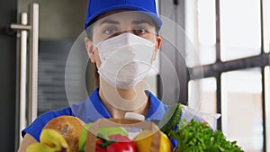 Delivery woman in face mask with food in paper bag