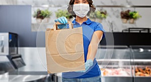 Delivery woman in face mask with paper bag