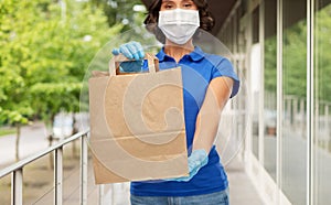 Delivery woman in face mask with paper bag