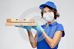 Delivery woman in face mask with pizza boxes