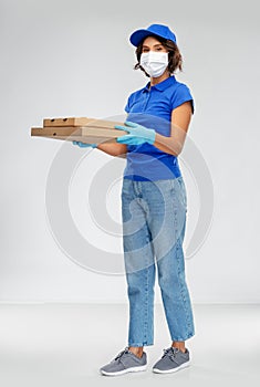 Delivery woman in face mask with pizza boxes