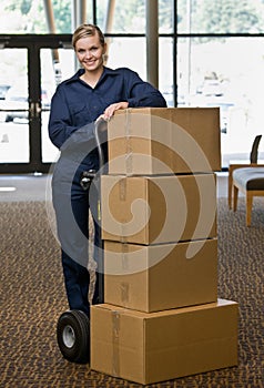 Delivery woman posing with stack of boxes