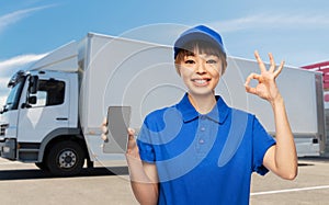 delivery woman with smartphone shows ok over truck