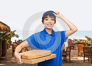 delivery woman with takeaway pizza boxes on beach