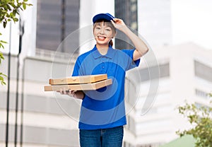 delivery woman with takeaway pizza boxes in city