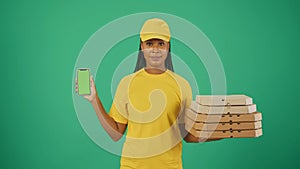 Delivery woman in uniform holding pizza boxes and smartphone. Advertising area, workspace mockup.