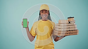 Delivery woman in uniform holding stack of pizza boxes with coffee and smartphone. Advertising area, workspace mockup.