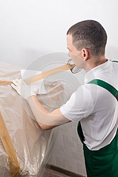 A delivery worker attaches a cover sheet with an order number before shipment, side view