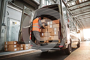 Delivery worker organizing boxes in back of cargo van