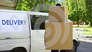 Delivery workman holding many cardboard boxes, express parcel shipment service