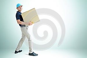 Deliveryman carrying a cardboard parcel box photo