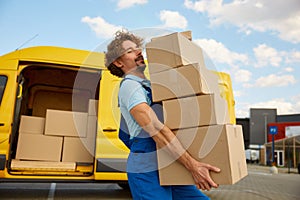 Deliveryman carrying pile of cardboard boxes