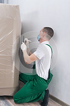 Deliveryman in a protective mask and gloves, rewrites the batch and delivery number before paperwork