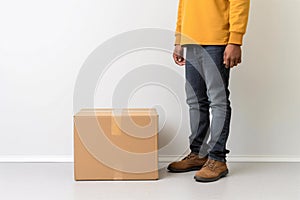 Deliveryman standing next to cardboard parcel box giving fast delivery service, transportation and logistics concept. Generative