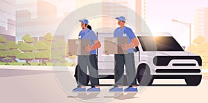 deliverymen holding cardboard boxes near delivery van couriers carrying parcels express delivery service happy labor day