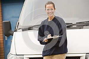 Deliveryperson standing with van writing