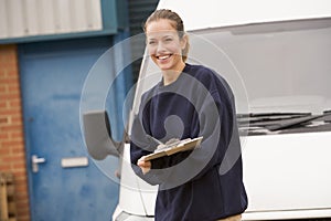 Deliveryperson standing with van writing