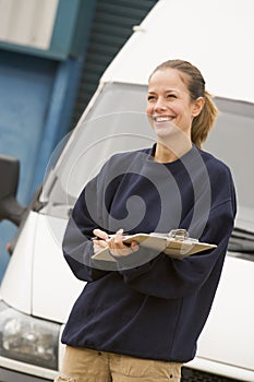 Deliveryperson standing with van writing