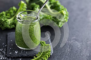 Delocious kale pesto sauce and fresh raw leaves photo