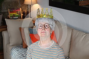 Delusional senior lady wearing a crown