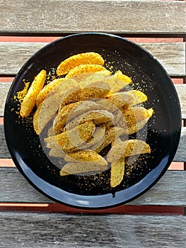 Deluxe potato fries on a black plate