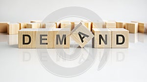 demand text on a wooden blocks, gray background