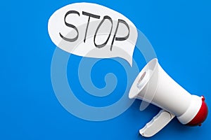 Demand to stop concept. Megaphone near cloud with word stop on blue background top view space for text