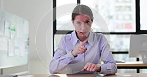 Demanding boss woman shows gesture at clock at workplace