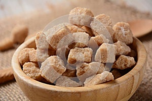 Demerara brown sugar cubes in wooden bowl. Also called sugar lumbs.