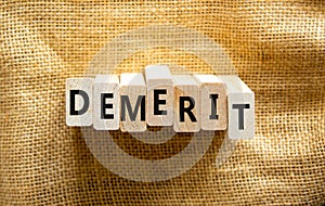 Demerit symbol. The concept word Demerit on wooden blocks. Beautiful canvas background, copy space. Business and demerit concept