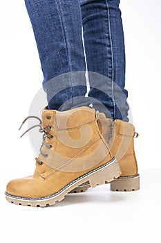 demi-season, women`s shoes, yellow, on the feet in jeans, white background