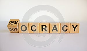 Democracy or autocracy symbol. Turned a cube and changed the word `autocracy` to `democracy`. Beautiful white background, copy