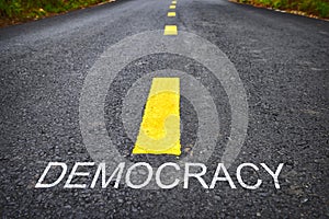 Democracy word on asphalt road