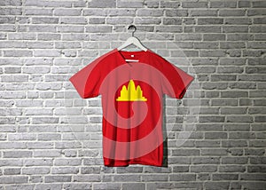Democratic Kampuchea flag on shirt and hanging on the wall with brick pattern wallpaper