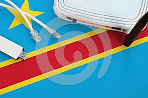 Democratic Republic of the Congo flag depicted on table with internet rj45 cable, wireless usb wifi adapter and router. Internet
