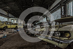 demolierte verlassene autos in einer halle