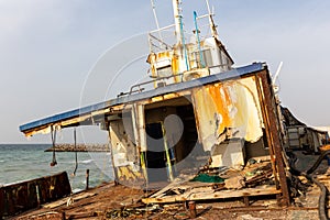 Demolished and rusty deck of a cargo ship with old bridge, mast, antennas and machinery