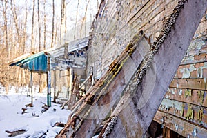 Demolished wooden structure in a forest area in winter