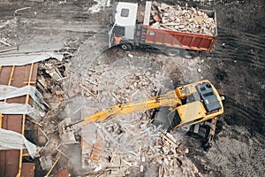 Demolition of building, aerial top view from drone. Excavator breaks old house. Freeing up space for construction of new