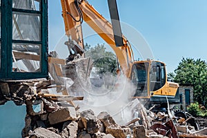 Demolition of building. Excavator destroy old house