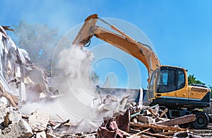 Demolition of building. Excavator destroy old house