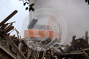 Demolition of the building with the help of technology, dust and trees around the wreckage of the building under the wheels