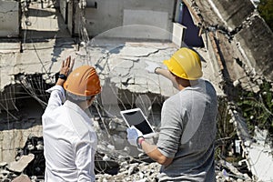 Demolition control supervisor and foreman discussing on demolish building