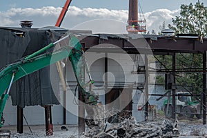 Demolition excavator rips off a building