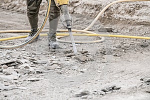 Demolition hammer. Male working in construction industry. Repairing and building a new road.