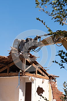 Demolition of house old building using excavator in city