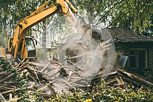 Demolition of old house. Excavator breaks building. City development, construction of new housing on site of old