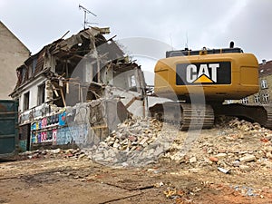 Demolition of an old house with yellow cat Excavator power shovel for building new apartments