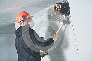 Demolition work and rearrangement. worker with sledgehammer destroying wall