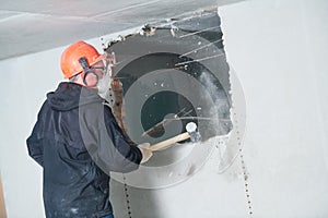 Demolition work and rearrangement. worker with sledgehammer destroying wall